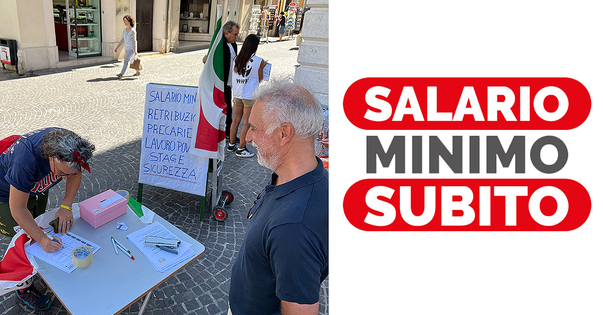 Al sinistra, il banchetto in piazza Roma, si vede una persona che firma la proposta di legge. A destra il logo della campagna "Salario Minimo Subito"
