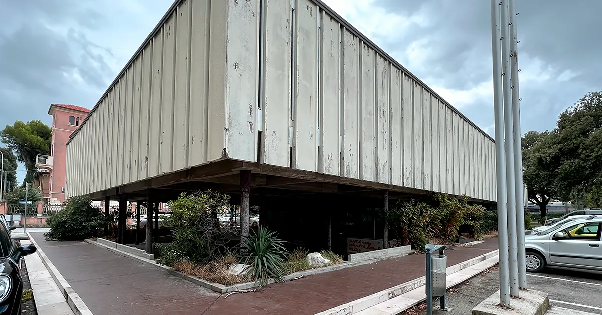 L'edificio si trova tra la stazione e lungomare, adiacente ai Giardini Morandi. Oggi si presenta come un blocco di cemento abbandonato, domani Olivetti intende trasformarlo in parcheggio multipiano, rovinando viabilità ed estetica del nostro lungomare