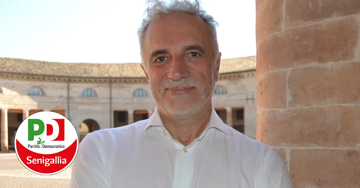 Massimo fotografato al Foro Annonario, in primo piano. Sorride, ha una leggera barba grgia, capelli corti grigi